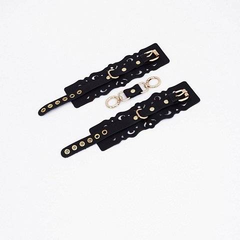 Черные кожаные наручники с узорами и золотистой фурнитурой